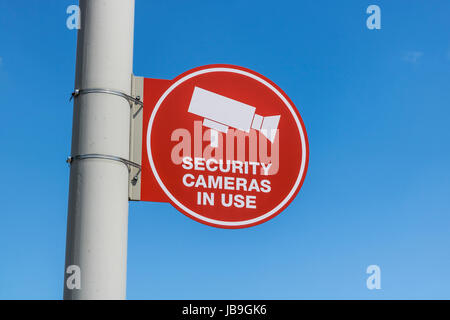 Red videocamera di sicurezza in uso Segno su grigio Post e prevalentemente soleggiato VI sfondo Foto Stock