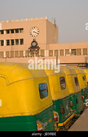 Fila di giallo risciò motorizzati al di fuori alla stazione ferroviaria di Nuova Delhi a Delhi, India. Foto Stock