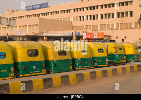 Fila di giallo risciò motorizzati al di fuori alla stazione ferroviaria di Nuova Delhi a Delhi, India. Foto Stock