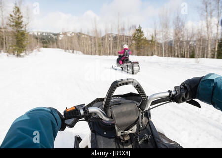 Sezione centrale della donna equitazione motoslitta durante il periodo invernale Foto Stock