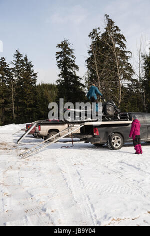 Caricamento uomo motoslitta su van durante il periodo invernale Foto Stock