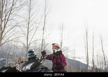Giovane rilassante in motoslitta nelle Alpi innevate durante il periodo invernale Foto Stock