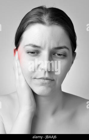 Giovane donna di toccare il suo orecchio doloroso Foto Stock