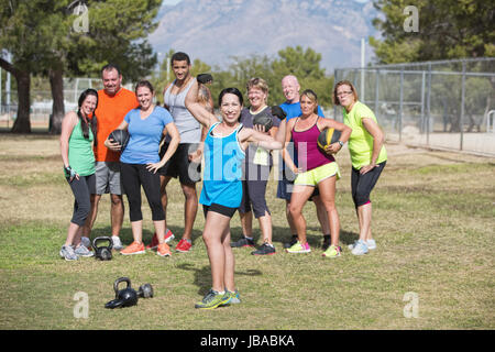 Donna sorridente in classe fitness lacerti di flessione Foto Stock