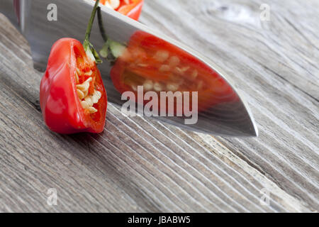 Halbierte Habanero Chilischote spiegelt sich im Messer Foto Stock