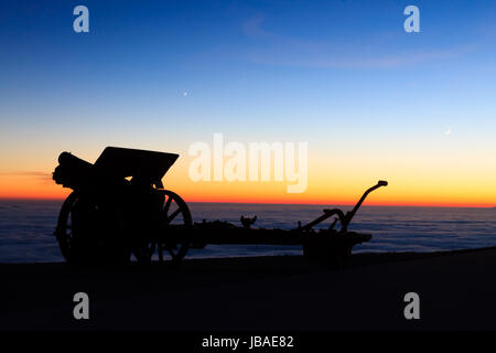 Silhouette di cannone al crepuscolo. Paesaggio notturno dalle Alpi italiane. Foto Stock