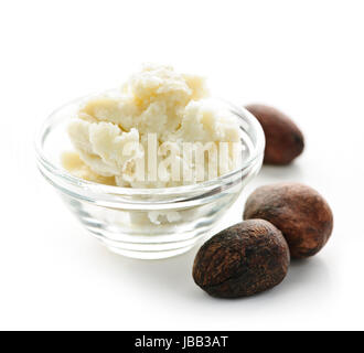 Noci di karité e sheabutter in recipiente di vetro isolato su bianco Foto Stock