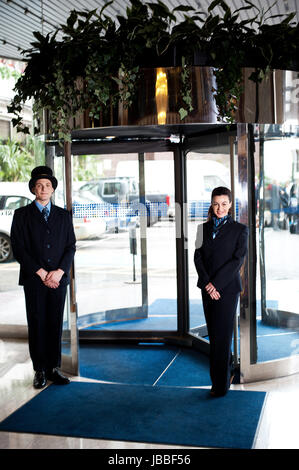 L'uomo porta con receptionist presso l'entrata. Area di parcheggio in background Foto Stock