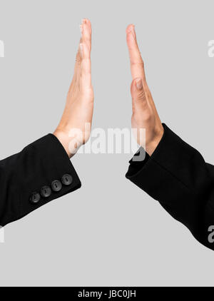 Le mani facendo un Dammi il cinque complimento su uno sfondo grigio Foto Stock