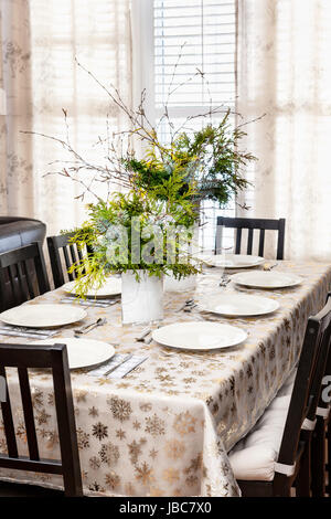 Tavolo da pranzo decorato per il Natale con otto le regolazioni del posto e evergreen centrotavola Foto Stock
