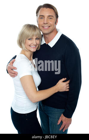 Elegante uomo in pullover abbracciando la sua bionda moglie. Entrambi sorridente alla fotocamera. Foto Stock