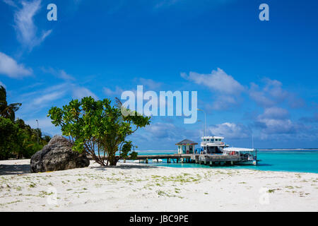 Imbarcazione attraccata ad un molo su un isola delle vacanze alle Maldive. Polvere di sabbia bianca e la lussureggiante vegetazione verde. la locale scuola di immersione opera da questo getto. Foto Stock