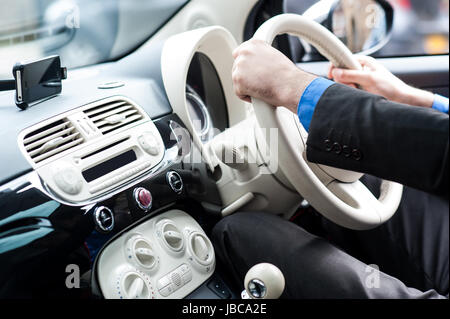 Uomo alla guida di una vettura con le mani sul volante. Foto Stock