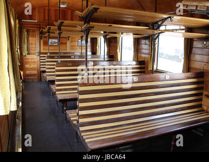 Vecchio vuoto panche di legno all'interno della carrozza ferroviaria. Foto Stock