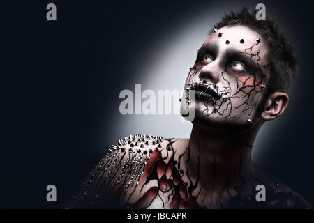 Un creepy Halloween trucco di un oscuro pensieroso moor con un peircing e corpo spaventoso art. Foto Stock