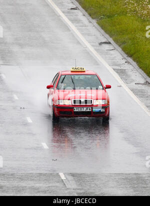 Motoristes affrontare il bagnato estate guidando lungo la A55 dual carridgeway vicino Halkn, Flintshire, Wales, Regno Unito Foto Stock