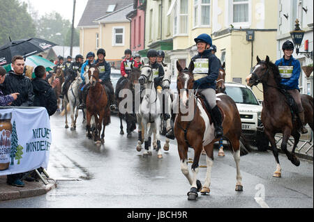 Hotel a Llanwrtyd Wells, Regno Unito. Il 10 giugno 2017. Cavalieri e cavalli vai all'inizio gate. . Giorno di pioggia per i concorrenti nell'uomo V maratona a cavallo. Guide & Horses competere in circa 35 km MAN V maratona di cavallo più robusto terreno gallese. L'evento è sponsorizzato da tutta la terra e di alimenti è stato concepito nel 1980 dal locatore Gordon Green dopo overhearing un pub dibattito nel Neuadd Arms, Llanwrtyd Wells, circa il fatto se un uomo era pari a horse running cross country sulla distanza. Credito: Graham M. Lawrence/Alamy Live News Foto Stock