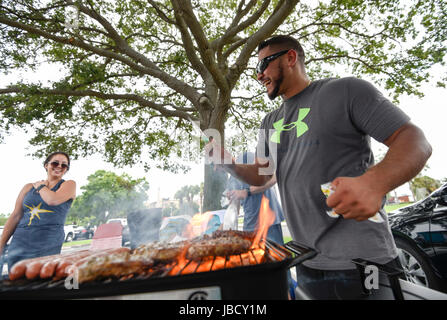 San Pietroburgo, Florida, Stati Uniti d'America. Decimo Giugno, 2017. CHRIS URSO | Orari.Orlando Ramirez, di Tampa, destra, cuochi hamburger e hotdog mentre tailgating nel parcheggio del campo Tropicana appena prima del primo gioco di Tampa Bay Rays a doppia testata contro la Oakland A's Sabato, 10 giugno 2017 a San Pietroburgo. Ramirez e i suoi amici e la famiglia erano ignari del fatto che i raggi sono state giocando due giochi di sabato. Quando è stato chiesto se avrebbero soggiorno per entrambi i giochi Ramirez ha risposto, "depends come ubriaco ci sono. Credito: Chris Urso/Tampa Bay volte/ZUMA filo/Alamy Live News Foto Stock