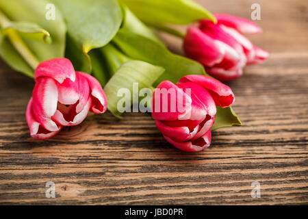 Bouquet di tulipani rossi su rustico sfondo di legno Foto Stock