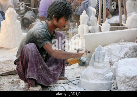 Locali di uomo che lavora su una statua vicino Mahamuni Pagoda di Mandalay, Myanmar. Mandalay è la seconda più grande città in Myanmar. Foto Stock