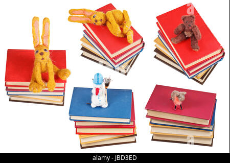Feltro soft giocattoli su vecchi libri isolati su sfondo bianco Foto Stock