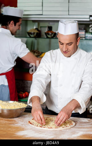 Due giovani cuochi al lavoro. Dietro le quinte. Foto Stock