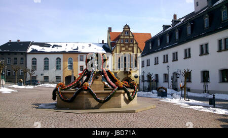 Auf dem Marktplatz der Kleinstadt Auma in Thüringen ist zu Ostern der Brunnen mit vielen bunten Ostereiern geschmückt, im Hintergrund Häuser und das Rathaus sul mercato della piccola cittadina di Auma nel Land della Turingia è a Pasqua decorate la fontana con molte colorate uova di Pasqua, sullo sfondo delle case e il municipio Foto Stock