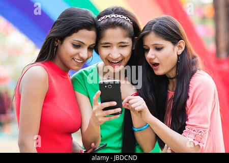 Sorpreso 3 adolescente ragazze amici lettura Telefono Messaggistica godere Fair Foto Stock