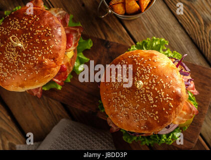 Due deliziosi hamburger fatti in casa sul tavolo in legno.Vista dall'alto. Foto Stock