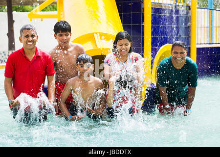Felice famiglia indiana del parco acquatico di balneazione piscina divertimento godere Foto Stock