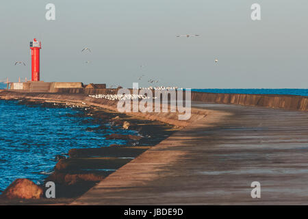 Faro rosso sul molo frangiflutti a Mar Baltico Foto Stock