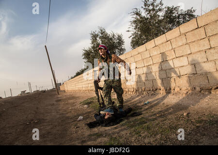 Chris Huby / Le Pictorium - Siria / Rojava - ira dell'Eufrate - 02/01/2017 - Rojava - Siria ROJAVA / DEC16 - Jan17. Villaggio Mahmudli. Un arabe SDF soldato è camminare su un ISIS corpo morto. Foto Stock
