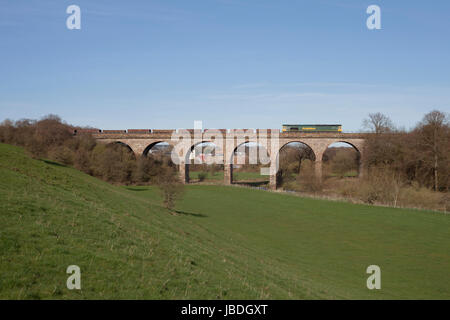 Freightliner Classe 66 locomotiva attraversa Hurlford viadotto a sud di Kilmarnock (Scozia) con un treno da una rete a binario sito di rinnovo Foto Stock