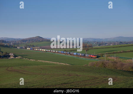 DB Cargo Classe 66 motrice passa teste pozzo (Sud di Oxenholme, Cumbria Regno Unito) con un Grangemouth-Daventry contenitore intermodale treno merci Foto Stock