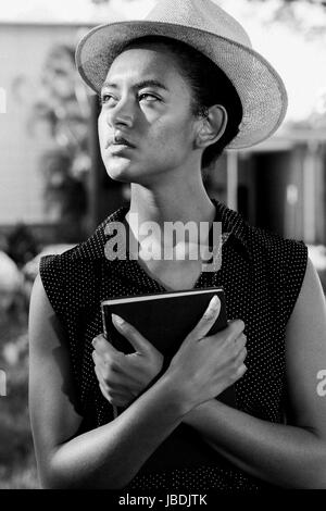 Elegante giovane donna in posa con Libro Foto Stock