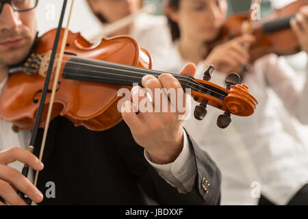 Musica classica orchestra sinfonica di stringa sezione esecuzione, violinista maschile riprodotto sul primo piano, la musica e il concetto di lavoro di squadra Foto Stock