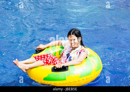 Happy 1 indian giovane donna rilassante anello gonfiabile piscina del resort godendo sorridente Foto Stock