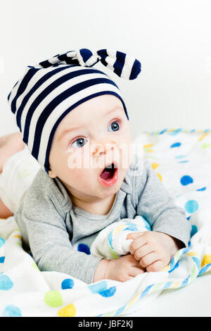 Divertente carino blue-eyed baby. Little Boy sbadigli Foto Stock