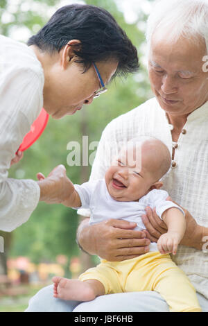 Cinese asiatici nonni giocando con il bambino nipote al giardino esterno. Foto Stock