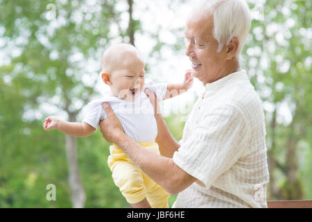 Felice cinese asiatici il nonno e nipote divertendosi al giardino esterno. Foto Stock