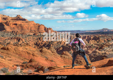 Escursionista permanente sulla montagna per l'onda in Nord Coyote Buttes, Arizona Foto Stock