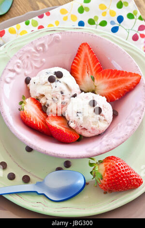 Eis mit Erdbeeren und Schokolade in rosa Schuessel Foto Stock