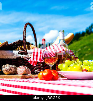 Assaggiato picnic sul prato vicino a un lago Foto Stock