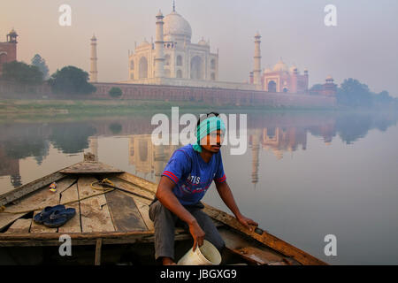 Uomo locale affidando l'acqua fuori della barca sul fiume Yamuna vicino al Taj Mahal al mattino, Agra, Uttar Pradesh, India. Foto Stock