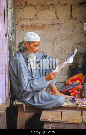 Uomo locale quotidiano di lettura alla strada del mercato di Fatehpur Sikri, Uttar Pradesh, India. La città è stata fondata nel 1569 dall'imperatore Mughal Akbar, un Foto Stock