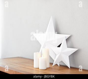 Stelle e candele accese su una sponda laterale come deco Foto Stock