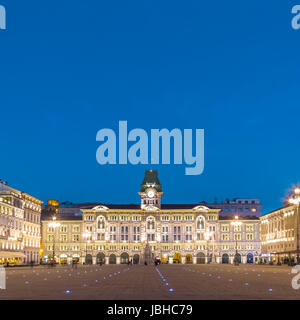 Il Municipio, il Palazzo del Municipio, è l'edificio che domina su Trieste la piazza principale Piazza dell Unita d Italia. Trieste, Italia, Europa. Città illuminata square shot al crepuscolo. Foto Stock