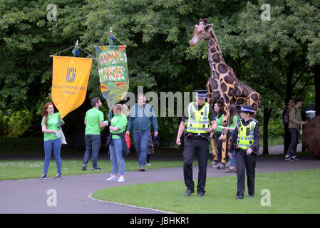 Glasgow, Scotland, Regno Unito. 11 giugno. I due elementi di questo anni estate britannica erano presenti come pioggia riversato verso il basso sul West End Festival grande domenica di Kelvingrove Park. I visitatori sono stati pesantemente controllata da parte della polizia e dei servizi di sicurezza privata. La polizia armata ha pattugliato il parco veicoli interno mentre sacchi sono stati perquisiti alle entrate da servizi privati di sicurezza personale. Gli ufficiali di polizia pattugliato il luogo a piedi e in bicicletta. Credito traghetto Gerard/Alamy Live News Foto Stock