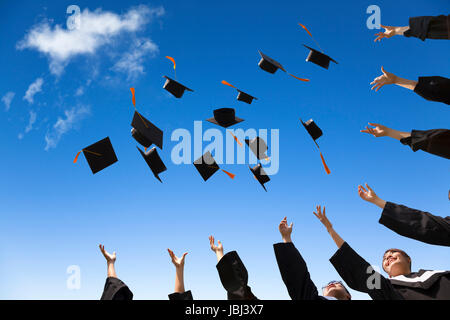 Gli studenti di gettare la laurea cappelli in aria per celebrare Foto Stock