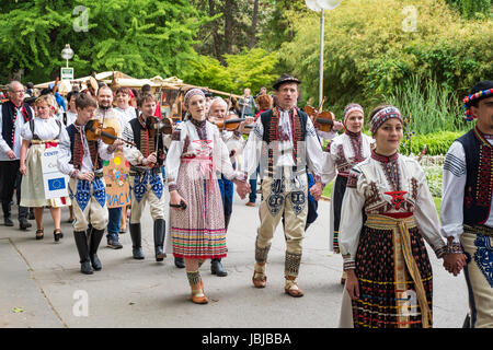 PIESTANY, Slovacchia - 20 Maggio 2017: un giovane non identificato, vestito in costumi folcloristici, canta una tradizionale canzone folk. Una folla di artigiani marche nell' Foto Stock